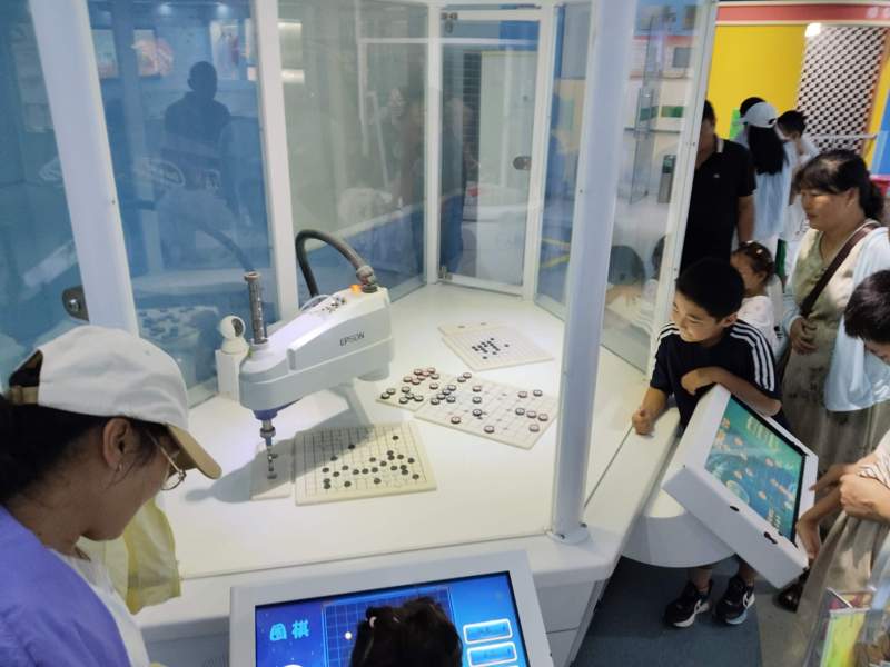 圖為游客與下棋機(jī)器人互動(dòng)